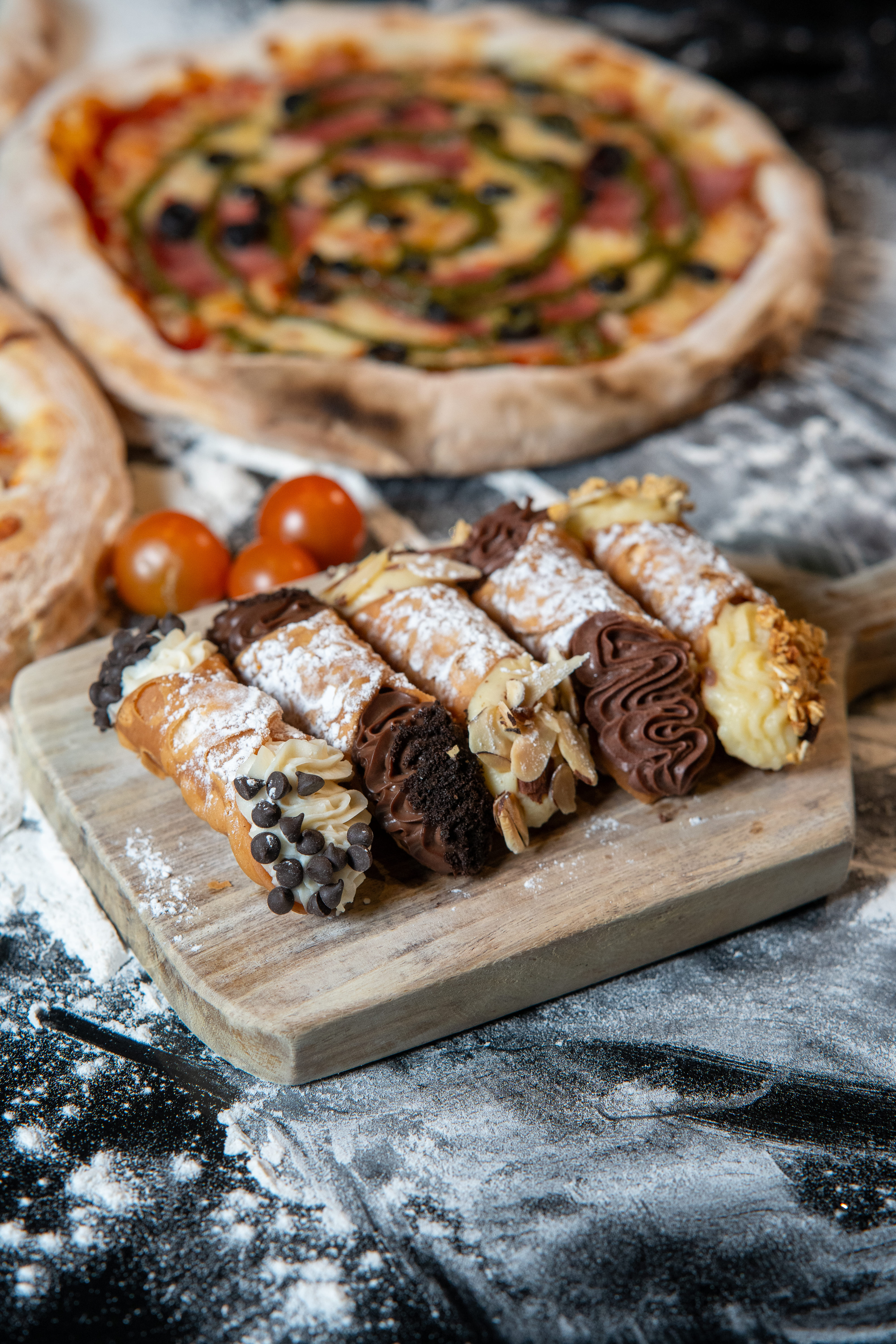 Composición en plano picado con un enfoque selectivo muy cerrado que resalta un grupo de cannolis con diferentes coberturas